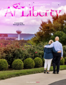 Cover of 2023 At Liberty shows a couple, arm in arm, looking at Beaver Stadium in State College, PA from The Village at Penn State campus