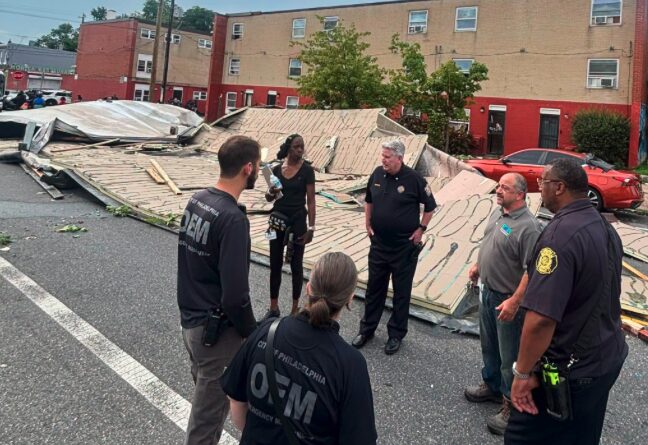 Officers of Emergency Management stand together to assess the storm damage.